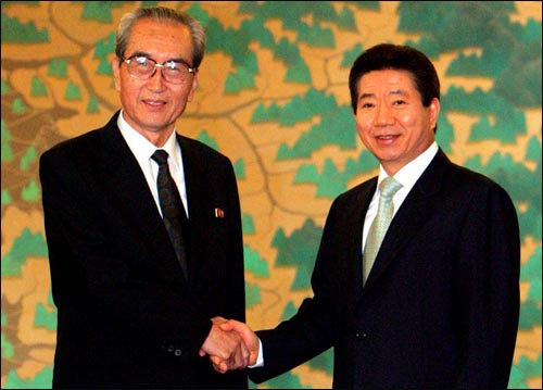 고 노무현 전 대통령이 2005년 8월 17일 청와대를 방문한 8.15민족대축전 김기남 북 대표와  악수하고 있다.